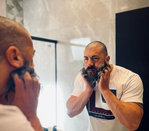 Homem cuidando da barba no espelho do banheiro